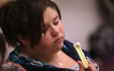 An Overweight Young Girl Examining a Healthy Snack