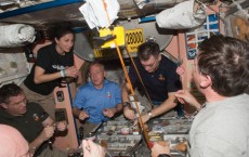 crew members share a meal in the Unity node of the International Space Station.